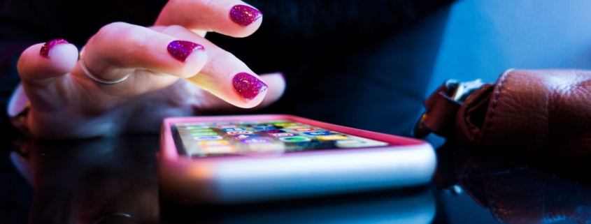 person using black smartphone with gray and pink case