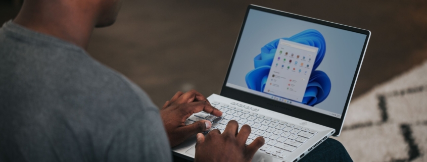 man in gray long sleeve shirt using Windows 11 computer