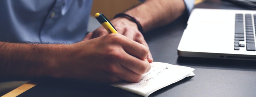 Free Person Writing on Paper Using Yellow and Black Pen Stock Photo